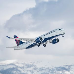 delta airbus a220 mid flight over mountains